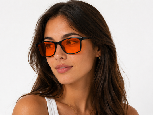 Woman wearing Deep Drift Solar Dusk blue light sleep glasses with amber lenses during evening screen use
