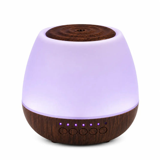Modern aroma diffuser with a white matte finish and dark wood base displayed on a plain white background with soft purple LED lighting and control buttons visible on the front.