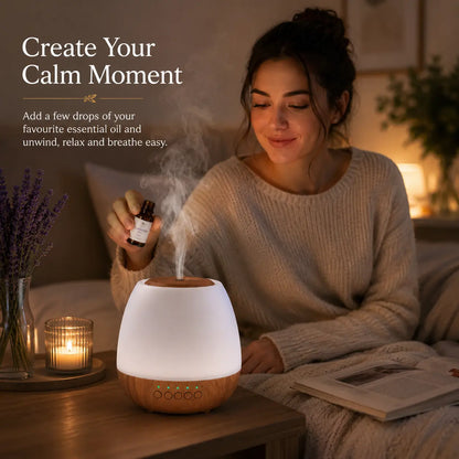 Woman adding essential oils to the Deep Drift aroma diffuser in a cosy bedroom to create a calming nighttime relaxation routine