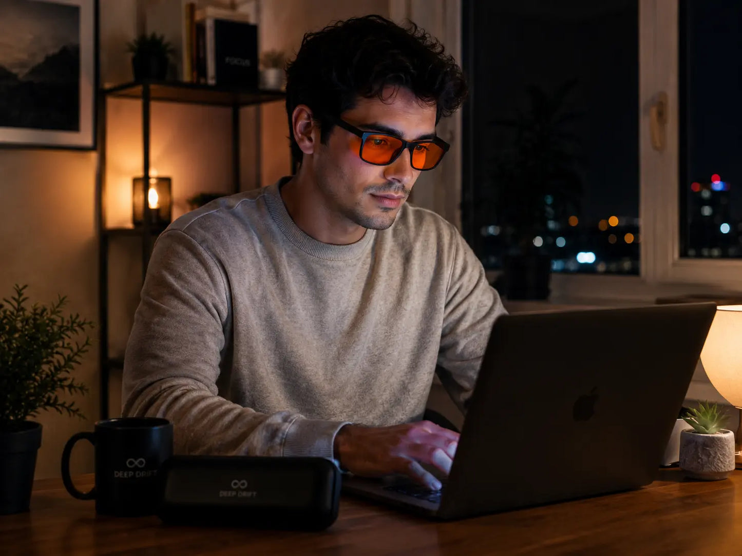 Person working on a laptop at night while wearing Deep Drift Solar Dusk amber blue light blocking glasses